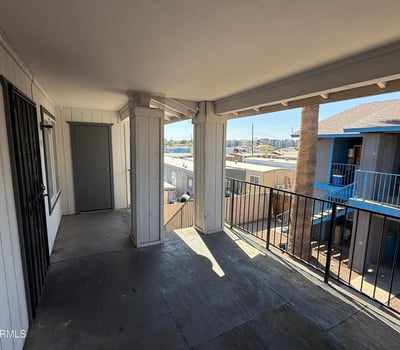 Second-level covered walkway with railings and open views overlooking the community grounds. This shaded exterior space enhances accessibility while contributing to the property's welcoming atmosphere.