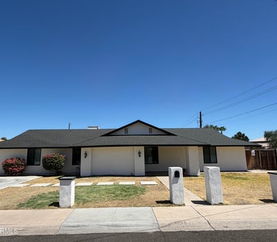 Beautiful front elevation highlighted by a covered entry, flowering shrubs, and clean desert-friendly landscaping. This move-in-ready home offers timeless style and convenience.