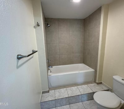 Well-sized bathroom featuring a tub and shower combination with updated tile surround and practical layout. Designed to provide comfort, convenience, and easy maintenance.