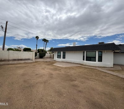Expansive backyard with desert-friendly landscaping and multiple outdoor seating opportunities. The generous lot size provides flexibility for pets, play, gardening, or future customization.