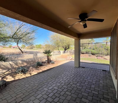 Covered patio featuring paver flooring, ceiling fan, screened enclosure, and peaceful views overlooking the golf course and professionally landscaped backyard. An ideal extension of the home's indoor living space.