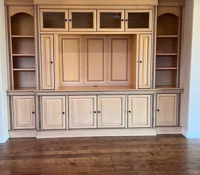 Beautiful custom entertainment wall featuring rich built-in cabinetry, open display shelves, enclosed storage, and premium craftsmanship that adds elegance and functionality to the great room.
