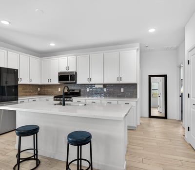 Cook with ease in this beautifully designed kitchen featuring stainless steel appliances, quartz countertops, stylish cabinetry, subway tile backsplash, and an oversized center island.
