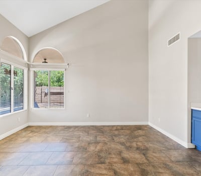 Vaulted ceilings and oversized windows create a bright, open family room with plenty of space for relaxing or entertaining. Its seamless connection to the kitchen enhances the home's functional floor plan.