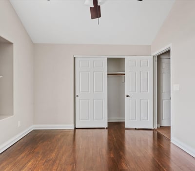 Wood flooring, ceiling fan, and a generously sized closet enhance this comfortable bedroom. The flexible layout works equally well for guests, family members, or a home office.