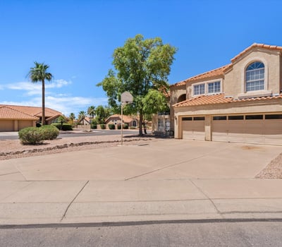 A broad front view highlights the home's attractive architecture, mature landscaping, and expansive driveway. This move-in-ready Chandler home combines timeless style with everyday convenience.