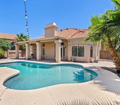 Enjoy resort-style outdoor living with a sparkling swimming pool, covered patio, mature tropical landscaping, and inviting entertaining spaces. This Chandler backyard is designed for relaxing and gathering year-round.