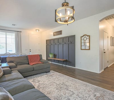 Stylish living room with luxury flooring, contemporary lighting, and a custom entry drop zone that adds organization and charm. A functional and inviting space for everyday living.
