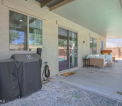 Large covered patio offering comfortable seating, shade, and seamless access to the backyard pool area. Perfect for outdoor gatherings and everyday living in this Waddell home.