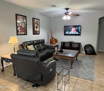 Comfortable great room with neutral finishes, tile flooring, ceiling fan, and an open floor plan designed to accommodate everyday living and entertaining with ease.