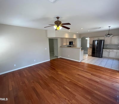 Rich wood flooring, recessed lighting, and an open floor plan make this inviting great room perfect for entertaining, family gatherings, or relaxing at home.