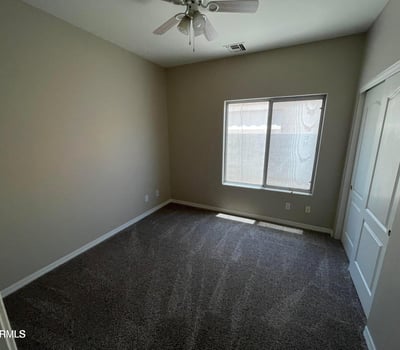 Featuring soft carpeting, a ceiling fan, natural light, and a spacious closet, this versatile bedroom easily accommodates guests, family, or a dedicated workspace.