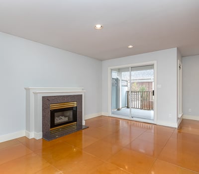 Bright and open living space featuring a cozy fireplace and access to a private outdoor balcony.