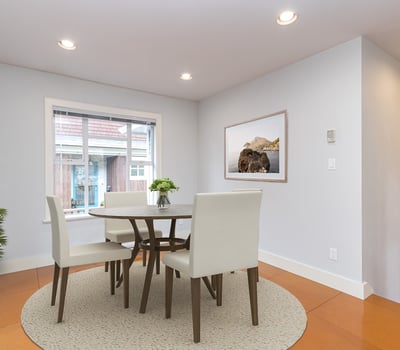 Bright and airy dining area featuring a modern table set and large windows for natural light.