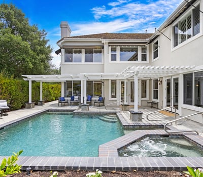 Discover a spacious outdoor oasis featuring a refreshing pool, spa, and ample lounging areas for relaxation.