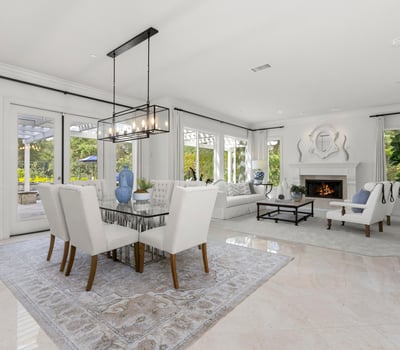 Bright and spacious living area with large windows, a cozy fireplace, and a seamless outdoor connection.