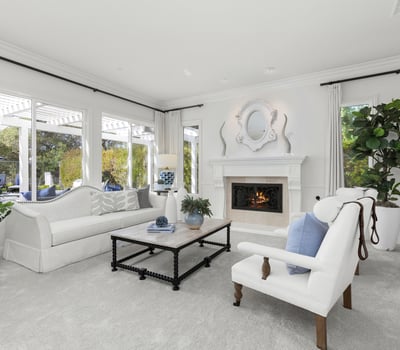 inviting living room featuring a cozy fireplace and large windows for abundant natural light.