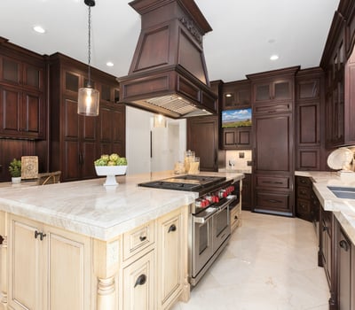 This gourmet kitchen features rich wood cabinetry, a spacious island, and premium appliances for culinary enthusiasts. 6 Burner Wolf Range with double ovens and griddle, 2 Bosch dishwashers, double sub zero fridges with 4 pull out freezer drawers, Wolf pull out microwave, tons of upgraded cabinets it pull out drawers, and so much more