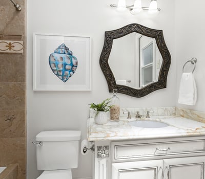En-Suite Bathroom for Bedroom 1 
Bright bathroom featuring a decorative mirror, modern fixtures, and unique artwork, enhancing its inviting atmosphere and private direct access door to backyard