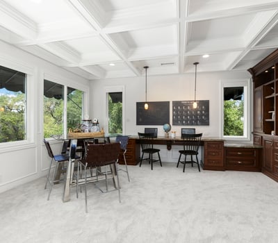 Loft/Entertaining Space featuring large windows, custom cabinetry, and versatile workspace for productivity.