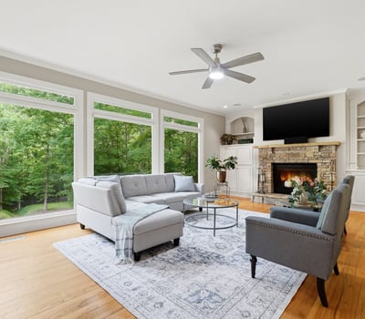 Bright and inviting living room featuring large windows, cozy fireplace, and spacious layout for entertaining.