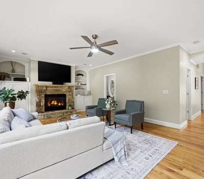 Spacious living area featuring a cozy fireplace, large windows, and modern finishes, ideal for gathering.