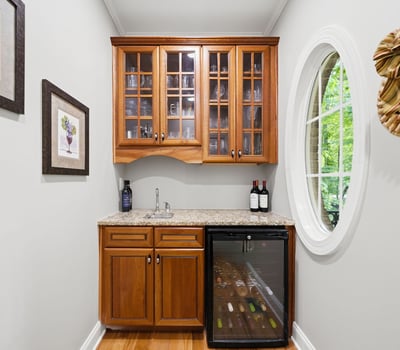 Perfect for entertaining, this cozy wine nook features stylish cabinetry and a compact fridge for easy access.