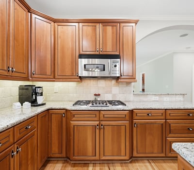 Experience this inviting kitchen, featuring rich wood cabinetry, granite counters, and modern stainless steel appliances.