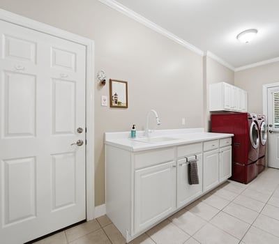 Spacious laundry room featuring ample counter space and modern appliances for efficient household tasks.