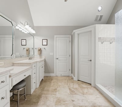 Spacious bathroom featuring dual vanities, modern fixtures, and a large walk-in shower for ultimate convenience.