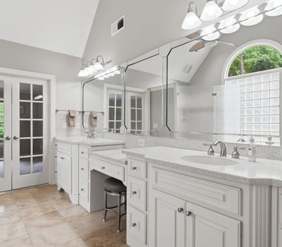 Spacious bathroom featuring dual vanities, abundant natural light, and access to a private outdoor space.