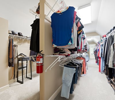 Spacious walk-in closet featuring abundant shelving for organized storage and natural light from skylights.