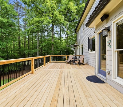 Spacious deck surrounded by lush greenery, perfect for outdoor gatherings and enjoying nature.