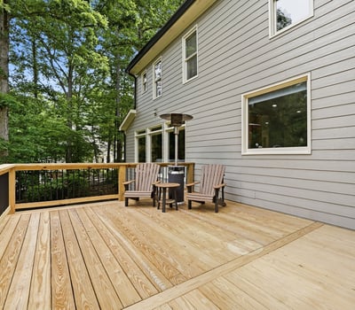 Spacious outdoor deck surrounded by trees, perfect for relaxing or entertaining in a private setting.
