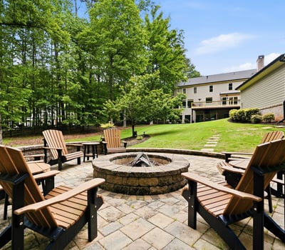 Gather around the fire pit in this spacious backyard, nestled among lush greenery and nature.