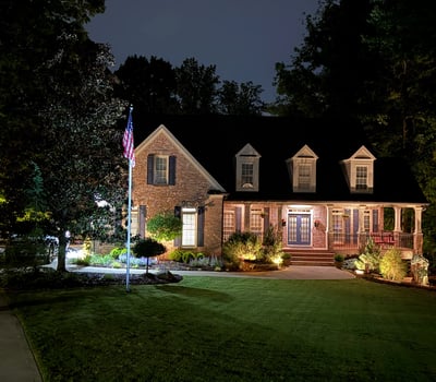 This beautifully illuminated home features inviting landscaping and ample outdoor space, perfect for evening gatherings.