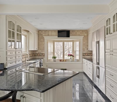 This modern kitchen features sleek cabinetry, granite countertops, and ample natural light for a functional workspace.
