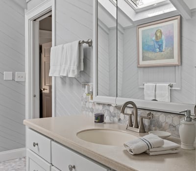 Bright and spacious bathroom featuring a skylight, natural stone accents, and modern fixtures for comfortable living.