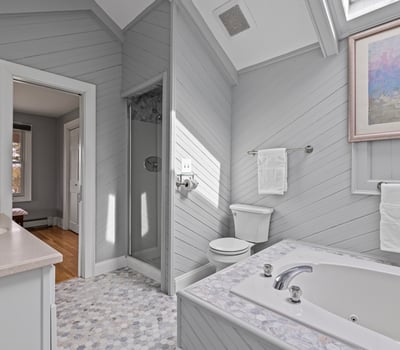 Bright and inviting bathroom featuring a soaking tub, walk-in shower, and modern finishes throughout.