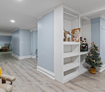 Bright and spacious basement with versatile layout, featuring built-in shelving and ample room for activities.