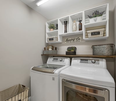 Bright laundry room features modern appliances and organized shelving for convenient storage and utility.