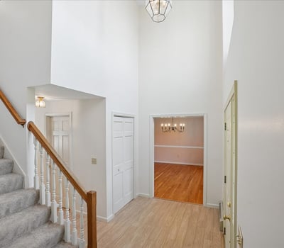 Spacious entryway featuring high ceilings and seamless flow to the inviting dining area and staircase.