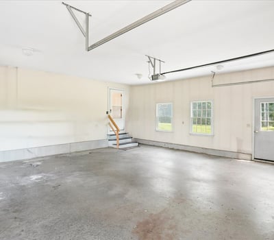 Spacious garage with ample natural light, featuring easy access to the backyard through a side door.