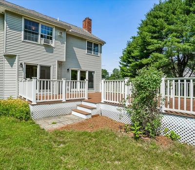 This spacious home features a large deck and lush backyard, perfect for outdoor gatherings and relaxation.