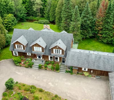 Spacious home surrounded by lush greenery, featuring multiple levels and ample outdoor space for recreation.