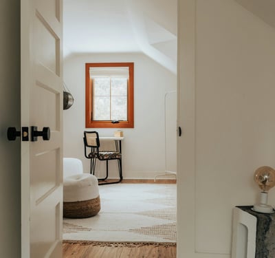 Bright and open room featuring a cozy workspace and unique architectural details, perfect for relaxation or creativity.