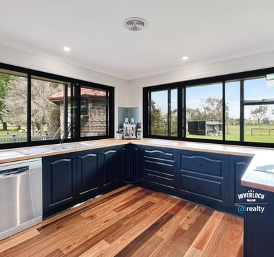 Modern kitchen with panoramic windows, featuring sleek cabinetry and scenic views of the surrounding landscape.