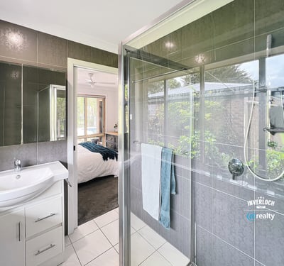 Modern bathroom featuring a spacious shower, sleek fixtures, and a seamless view of the landscaped garden.