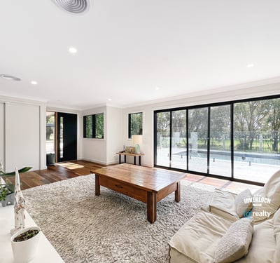 Spacious living area features large windows, abundant natural light, and direct access to outdoor spaces.