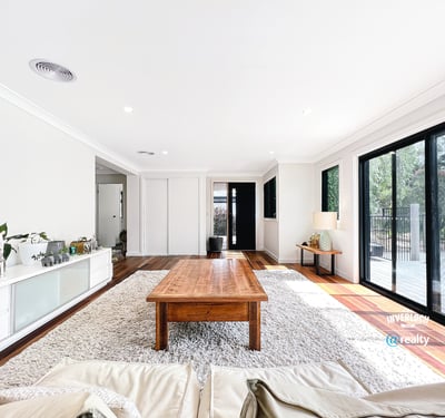 Bright open living space featuring large windows, natural light, and a warm wood coffee table.